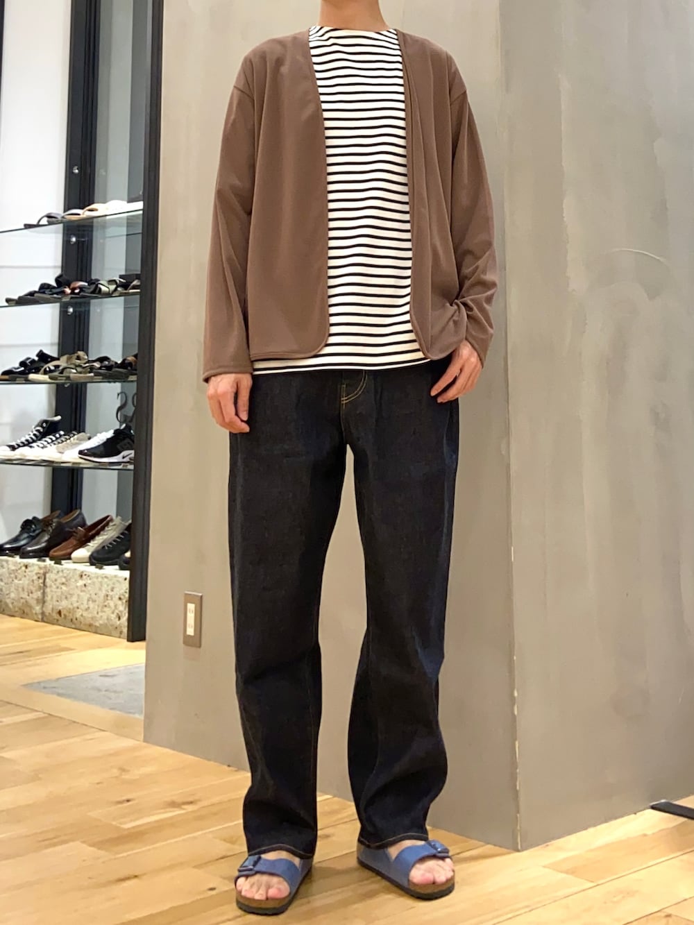 ブラウン系のカーディガン/ボレロ、ブルー系のデニムパンツ、ブルー系のサンダルを着用したメンズの春コーディネートの4枚目の写真