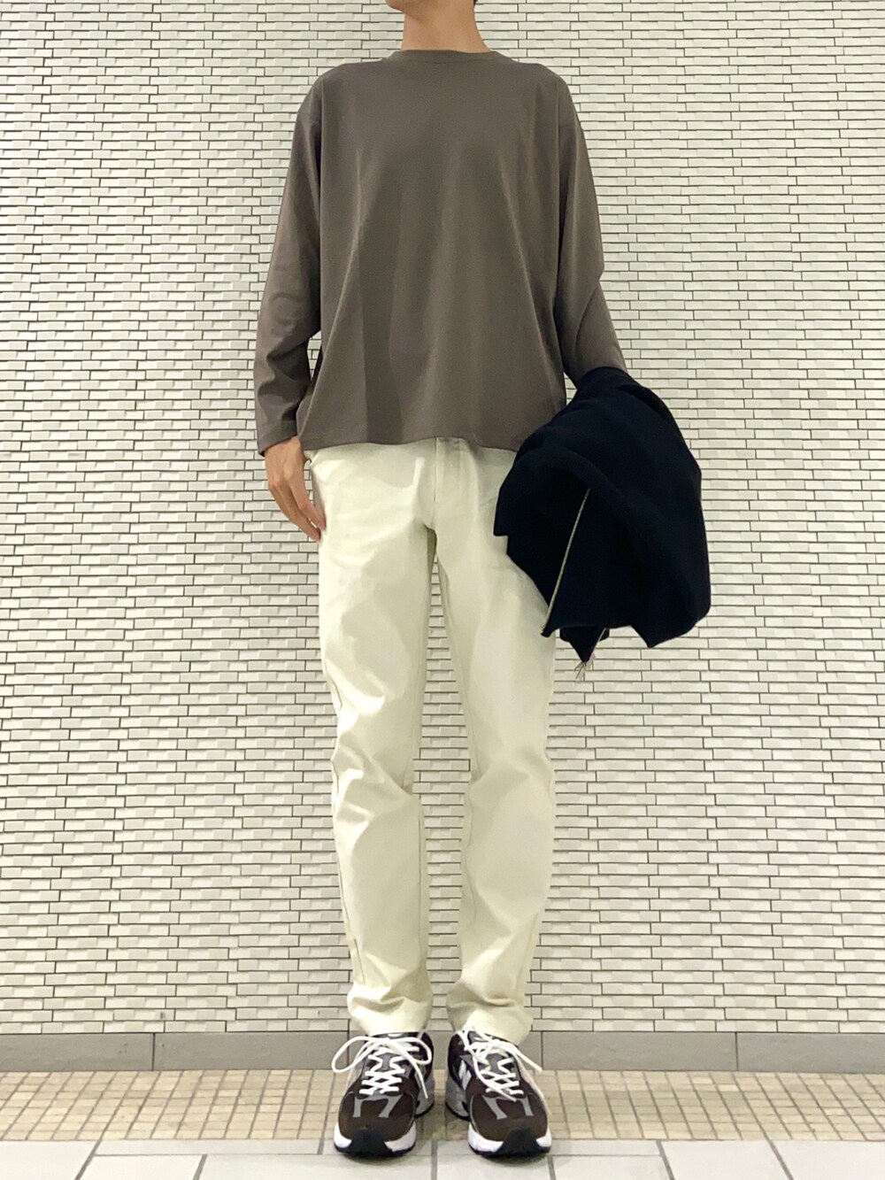 ブラック系のブルゾン、ブラウン系のTシャツ/カットソー、ホワイト系のその他パンツを着用したメンズの秋コーディネートの2枚目の写真