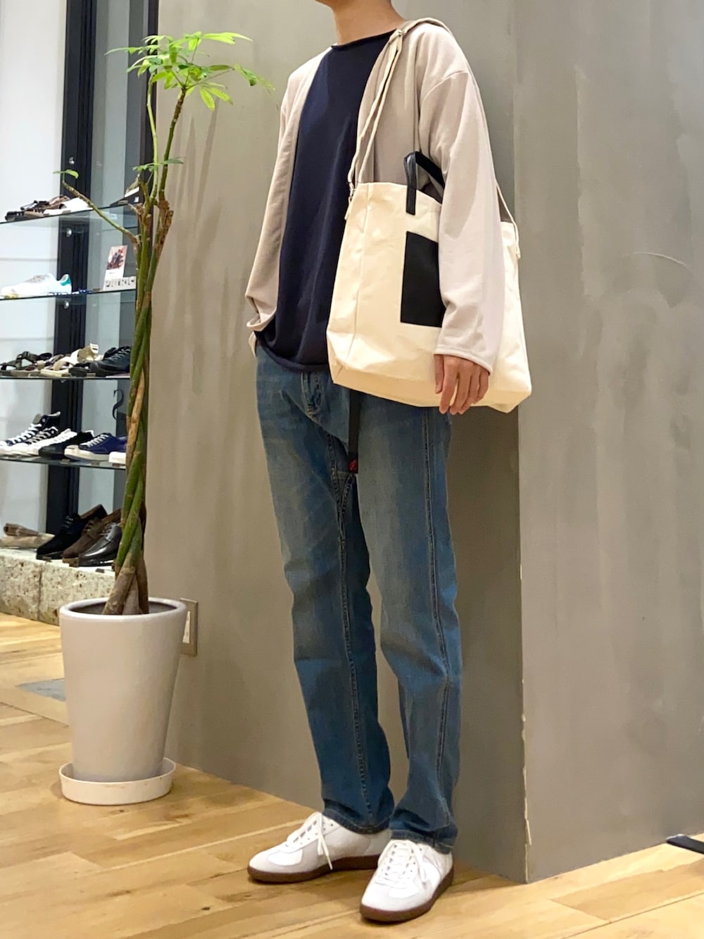 グレー系のカーディガン/ボレロ、ブルー系のTシャツ/カットソー、ホワイト系のスニーカーを着用したメンズの秋コーディネートの2枚目の写真