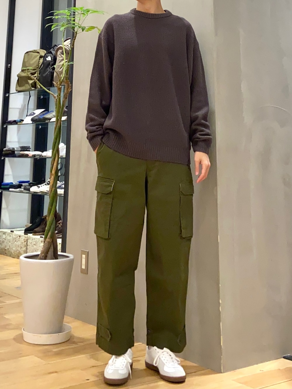 グレー系のダウンジャケット/コート、グレー系のニット/セーター、ホワイト系のスニーカーを着用したメンズの冬コーディネートの2枚目の写真