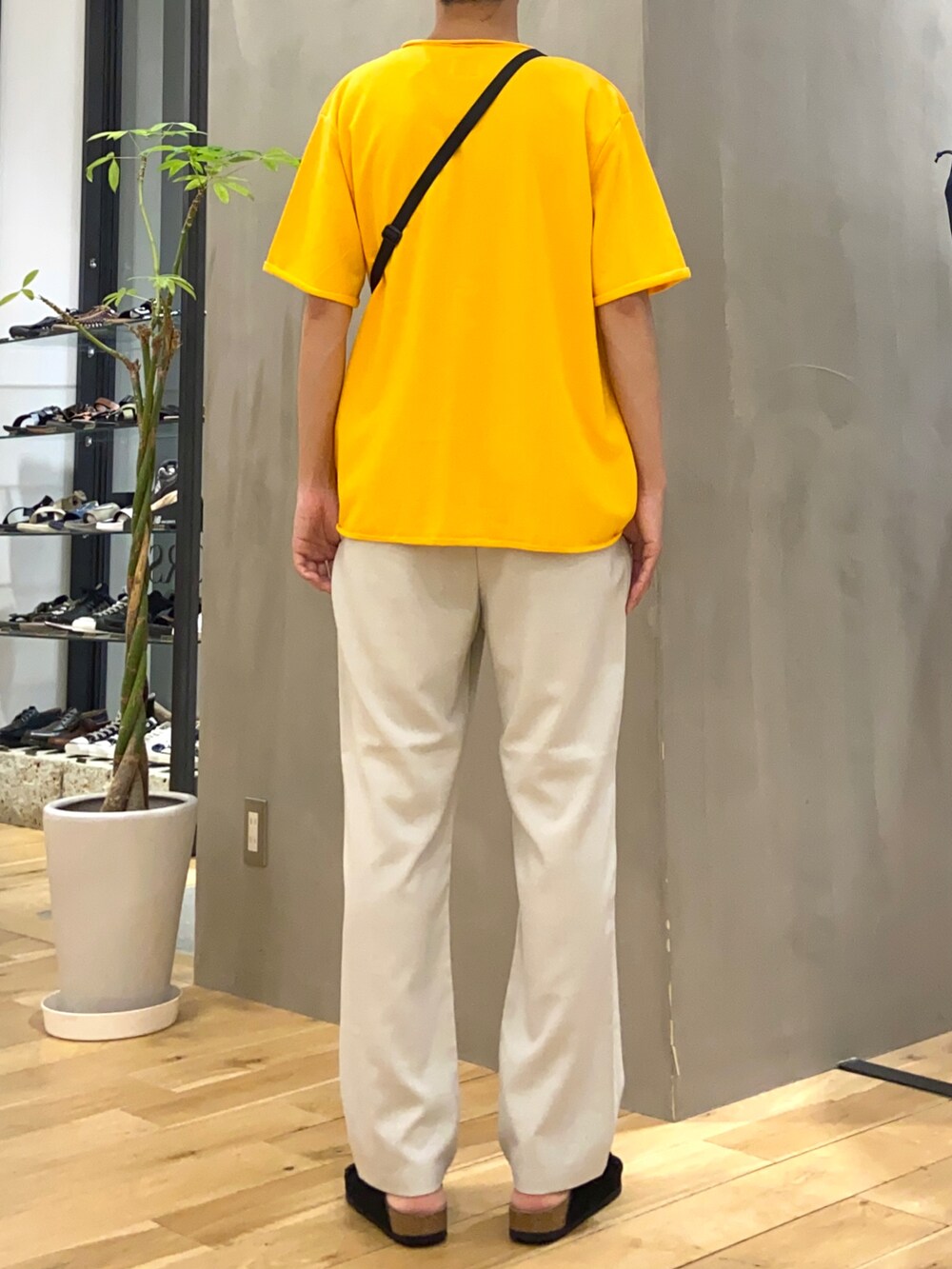 イエロー系のTシャツ/カットソー、ブラック系のショルダーバッグ、ホワイト系のその他パンツを着用したメンズの夏コーディネートの3枚目の写真
