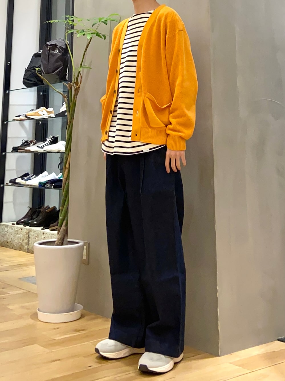 オレンジ系のカーディガン/ボレロ、ホワイト系のTシャツ/カットソー、ブルー系のデニムパンツを着用したメンズの春コーディネートの3枚目の写真