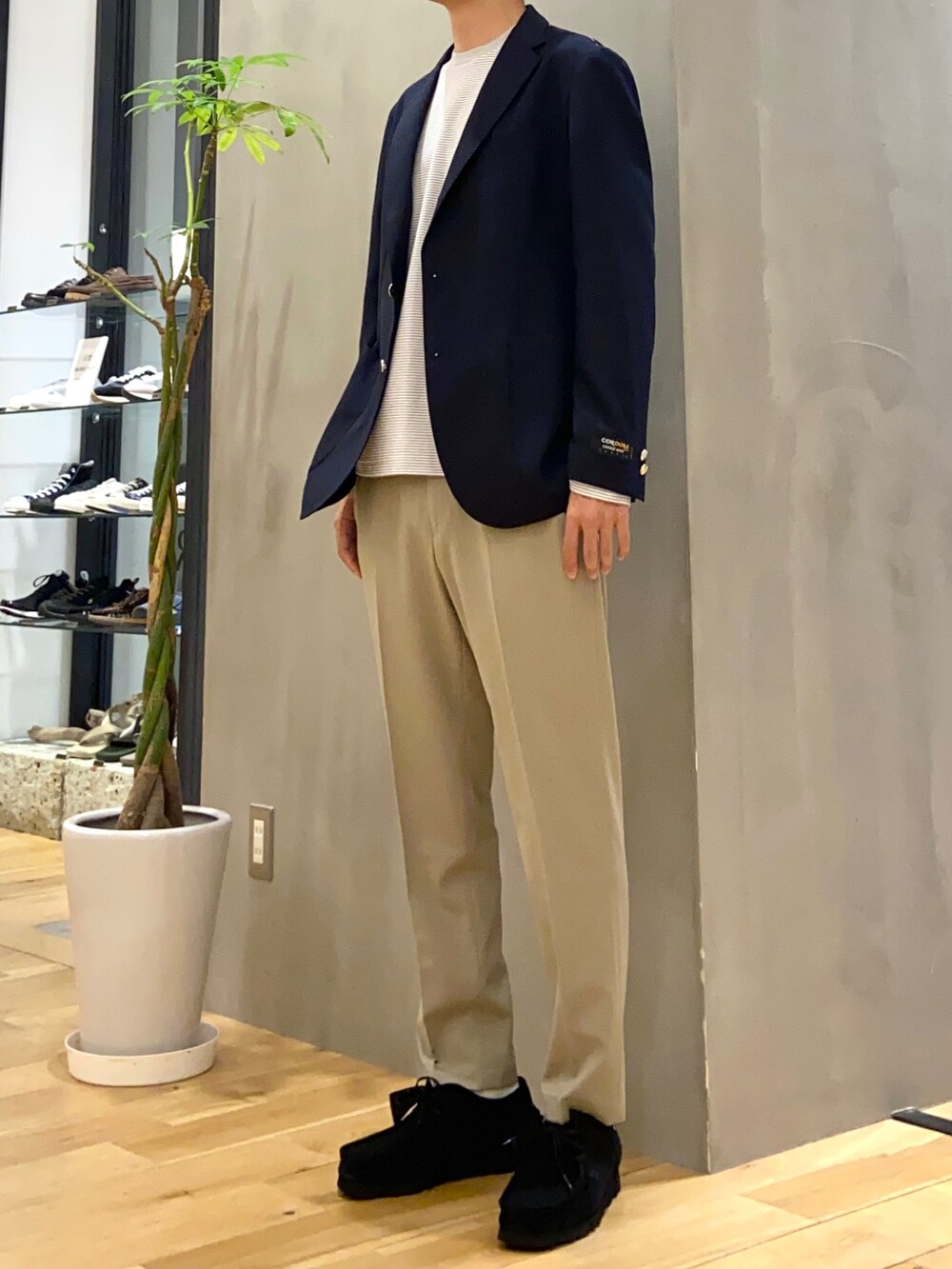 ブルー系のその他アウター、ホワイト系のTシャツ/カットソー、ベージュ系のスーツパンツを着用したメンズの秋コーディネートの3枚目の写真