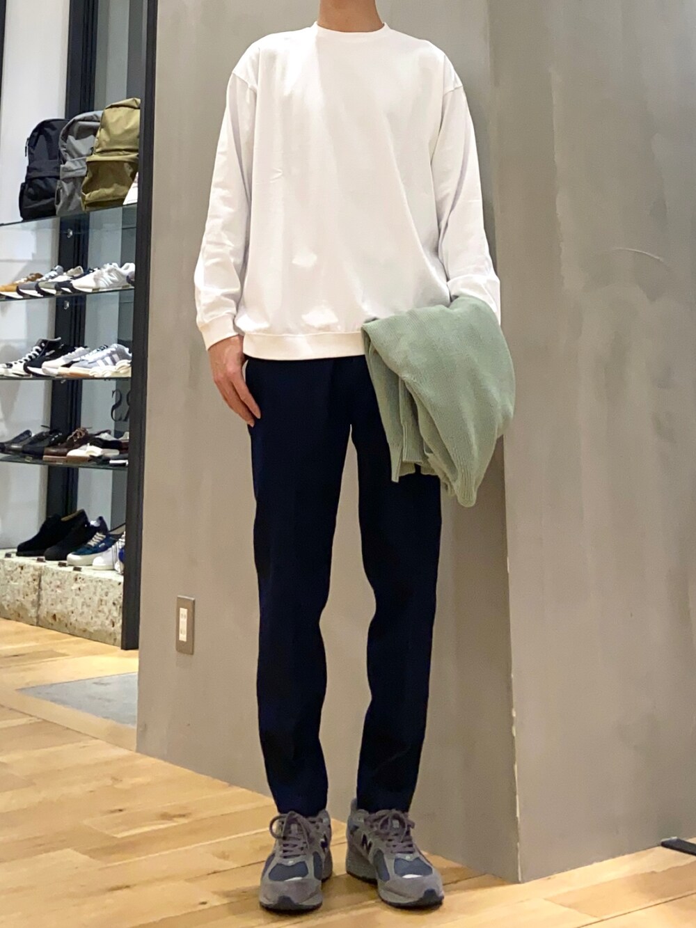 グリーン系のカーディガン/ボレロ、ホワイト系のTシャツ/カットソー、ブルー系のデニムパンツを着用したメンズの春コーディネートの2枚目の写真