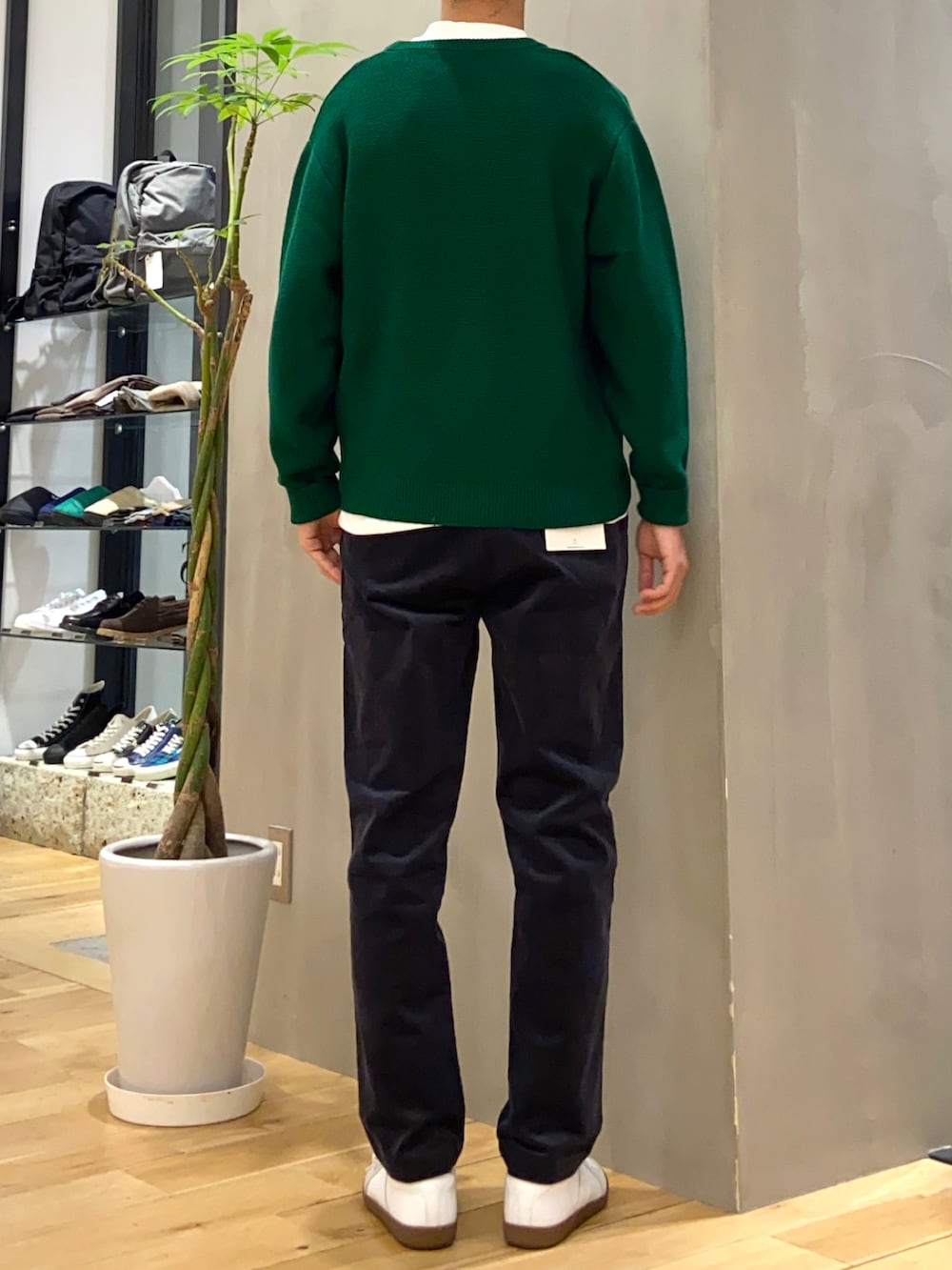 グリーン系のニット/セーター、ホワイト系のTシャツ/カットソー、ホワイト系のスニーカーを着用したメンズの秋コーディネートの3枚目の写真
