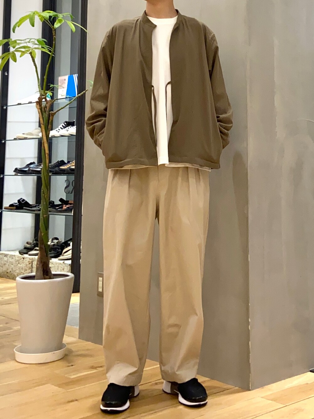 グリーン系のブルゾン、ホワイト系のTシャツ/カットソー、ベージュ系のその他パンツを着用したメンズの春コーディネートの2枚目の写真