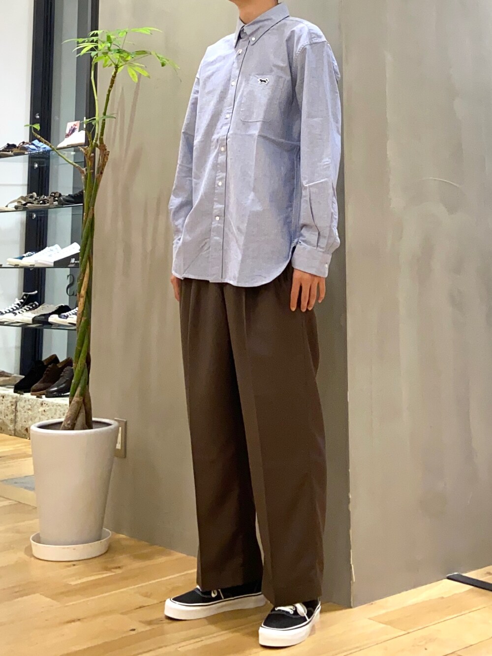 ブラウン系のその他パンツ、ブラック系のスニーカー、ブルー系のシャツ/ブラウスを着用したメンズの秋コーディネートの3枚目の写真