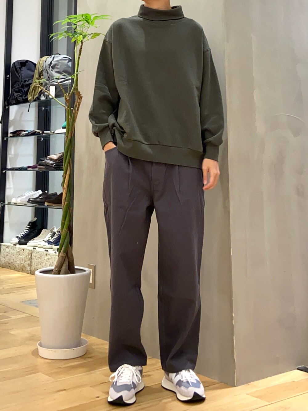 グレー系のダウンベスト、グリーン系のスウェット、グレー系のその他パンツを着用したメンズの秋コーディネートの2枚目の写真