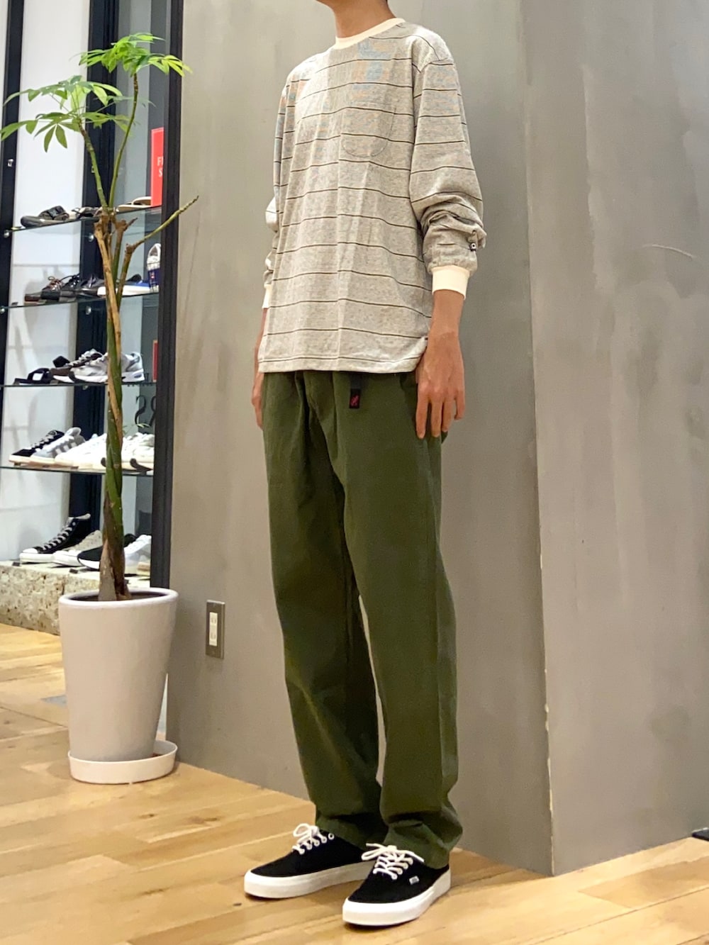 ホワイト系のTシャツ/カットソー、グリーン系のその他パンツ、ブラック系のスニーカーを着用したメンズの秋コーディネートの2枚目の写真