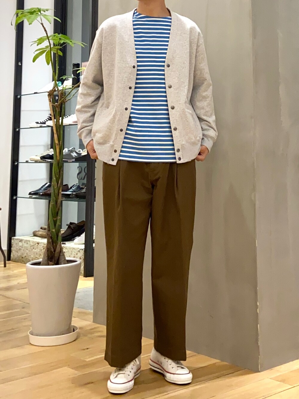 グレー系のステンカラーコート、グレー系のカーディガン/ボレロ、ブラウン系のその他パンツを着用したメンズの冬コーディネートの2枚目の写真