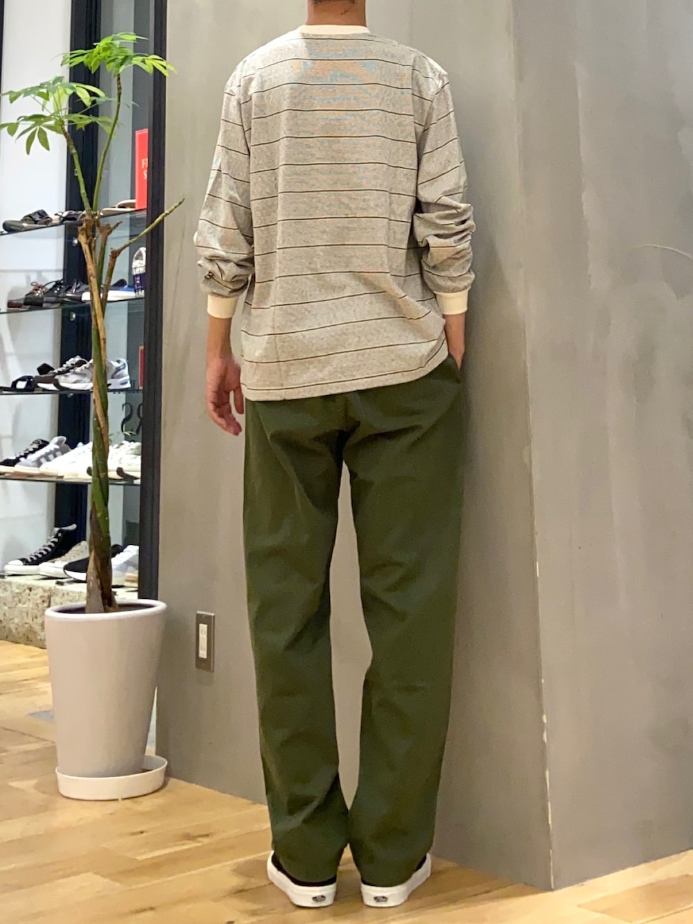 ホワイト系のTシャツ/カットソー、グリーン系のその他パンツ、ブラック系のスニーカーを着用したメンズの秋コーディネートの3枚目の写真