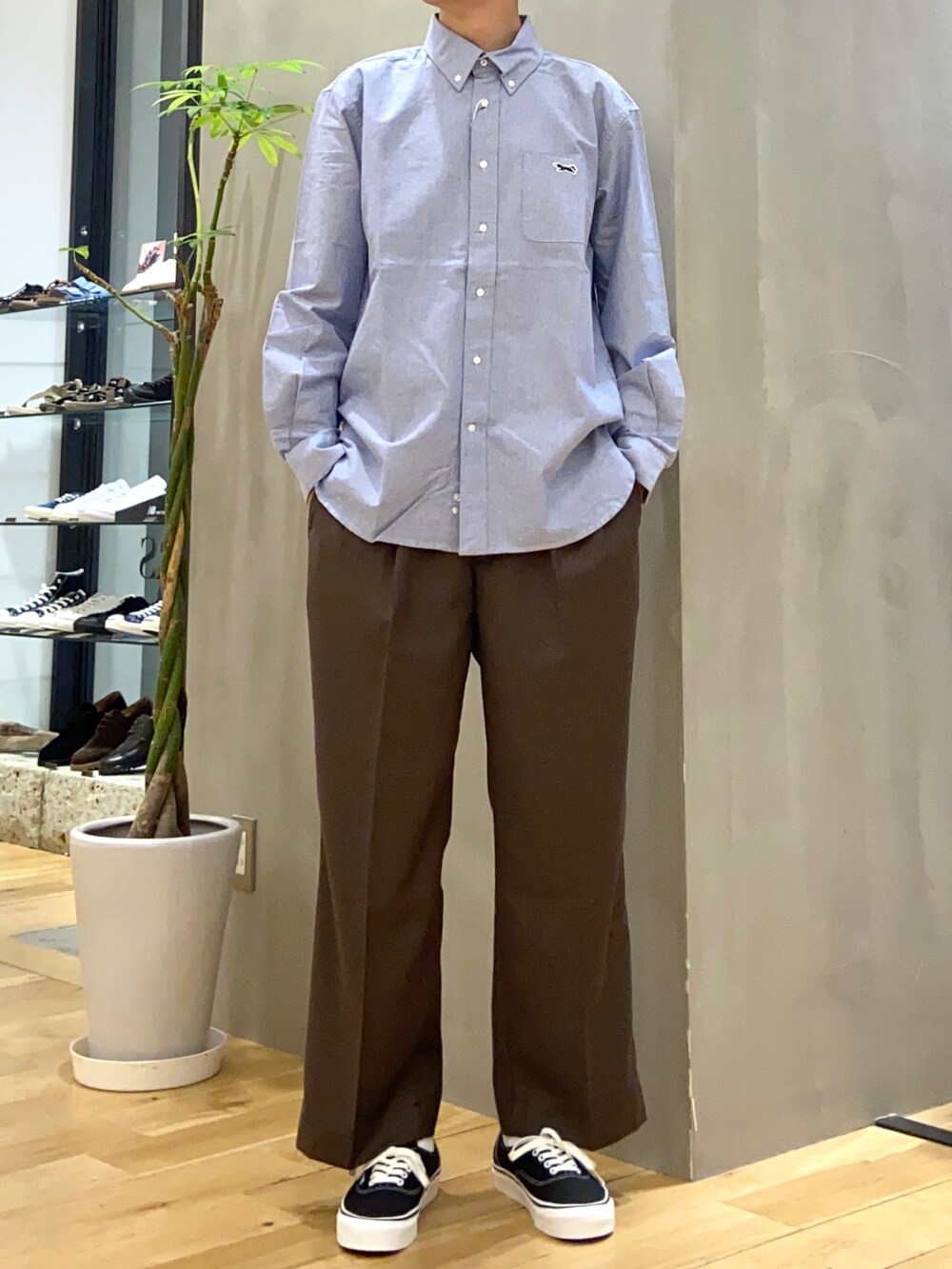 ブラウン系のその他パンツ、ブラック系のスニーカー、ブルー系のシャツ/ブラウスを着用したメンズの秋コーディネートの2枚目の写真