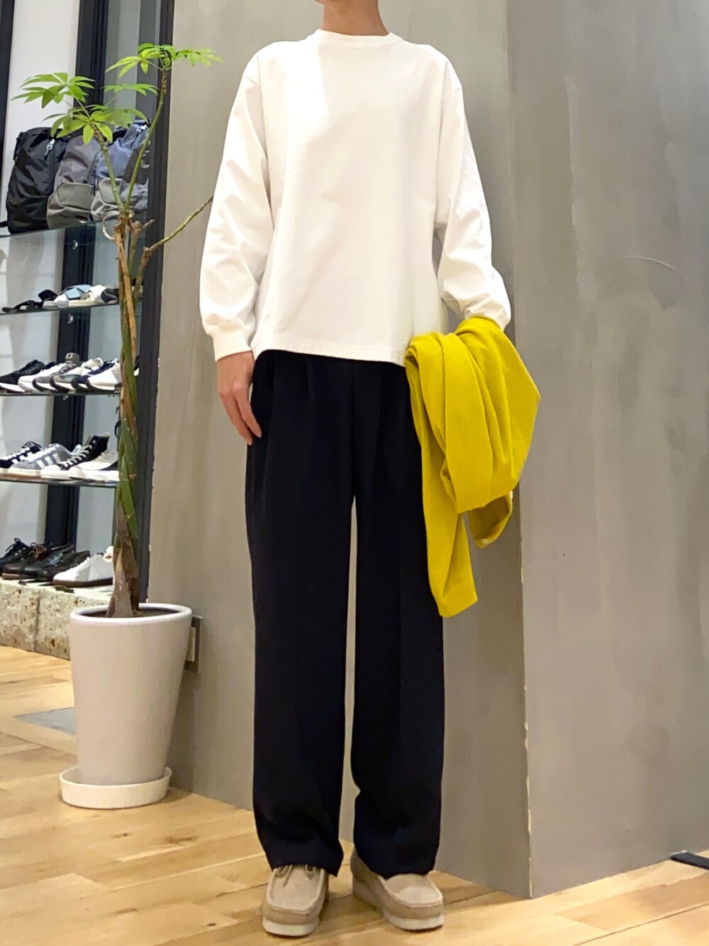 イエロー系のカーディガン/ボレロ、ホワイト系のTシャツ/カットソー、ブルー系のスラックスを着用したメンズの春コーディネートの2枚目の写真