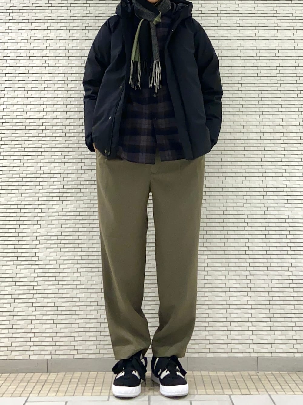 ブラック系のダウンジャケット/コート、ブラウン系のシャツ/ブラウス、グレー系のその他パンツを着用したメンズの冬コーディネートの4枚目の写真