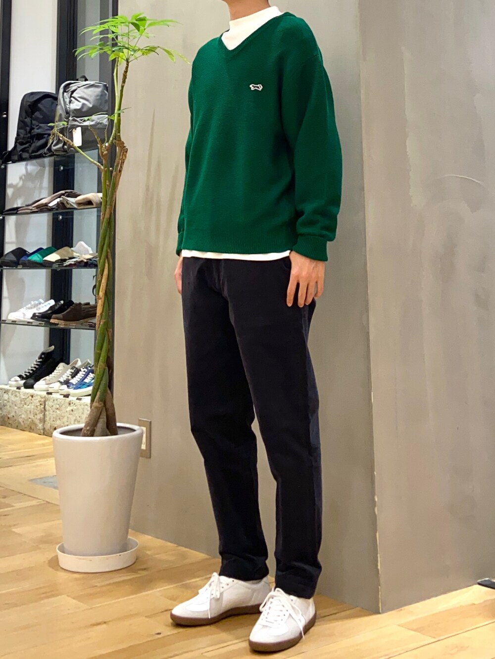 グリーン系のニット/セーター、ホワイト系のTシャツ/カットソー、ホワイト系のスニーカーを着用したメンズの秋コーディネートの2枚目の写真