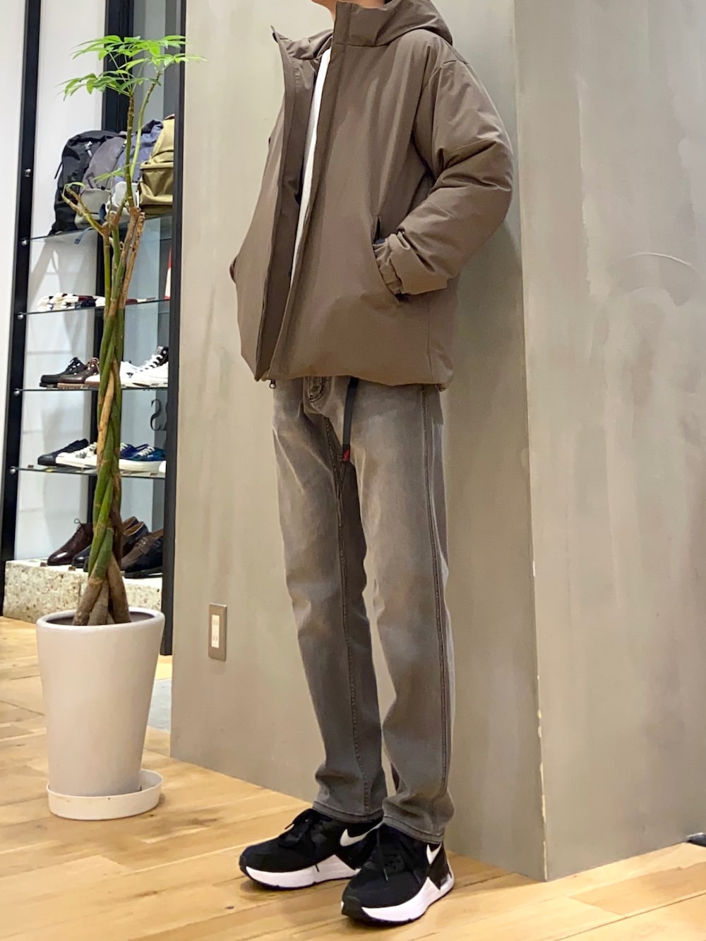 グリーン系のダウンジャケット/コート、ホワイト系のニット/セーター、ブラック系のその他パンツを着用したメンズの冬コーディネートの3枚目の写真