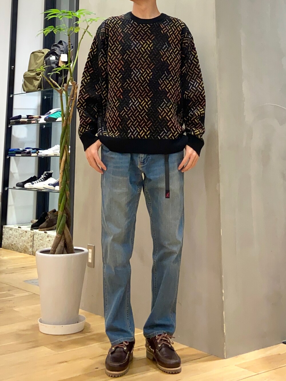 ブラック系のダウンジャケット/コート、ブルー系のその他パンツ、ブラウン系のスニーカーを着用したメンズの冬コーディネートの2枚目の写真