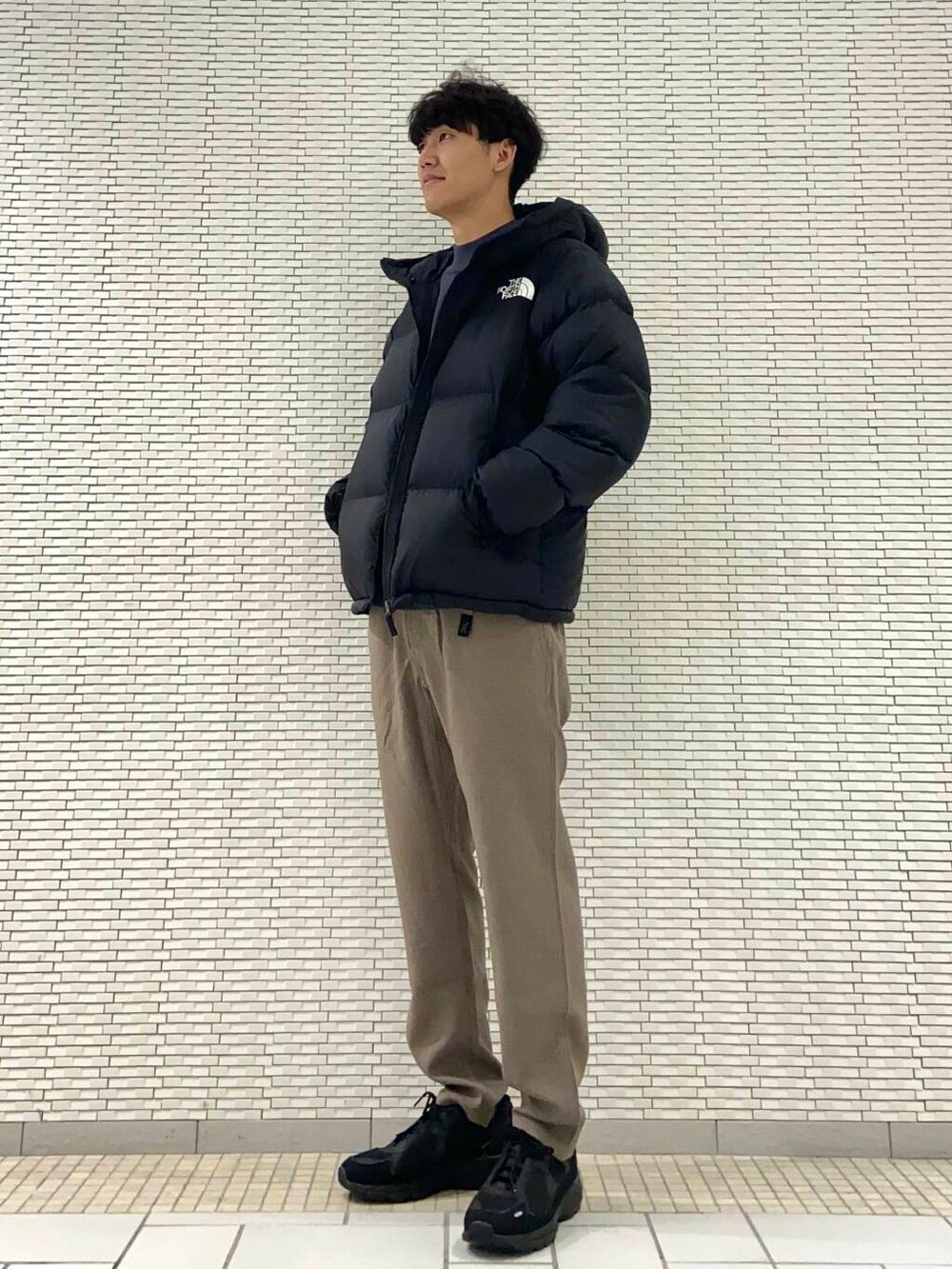 ブラウン系のその他パンツ、ブルー系のニット/セーター、ブラック系のスニーカーを着用したメンズの秋コーディネートの2枚目の写真