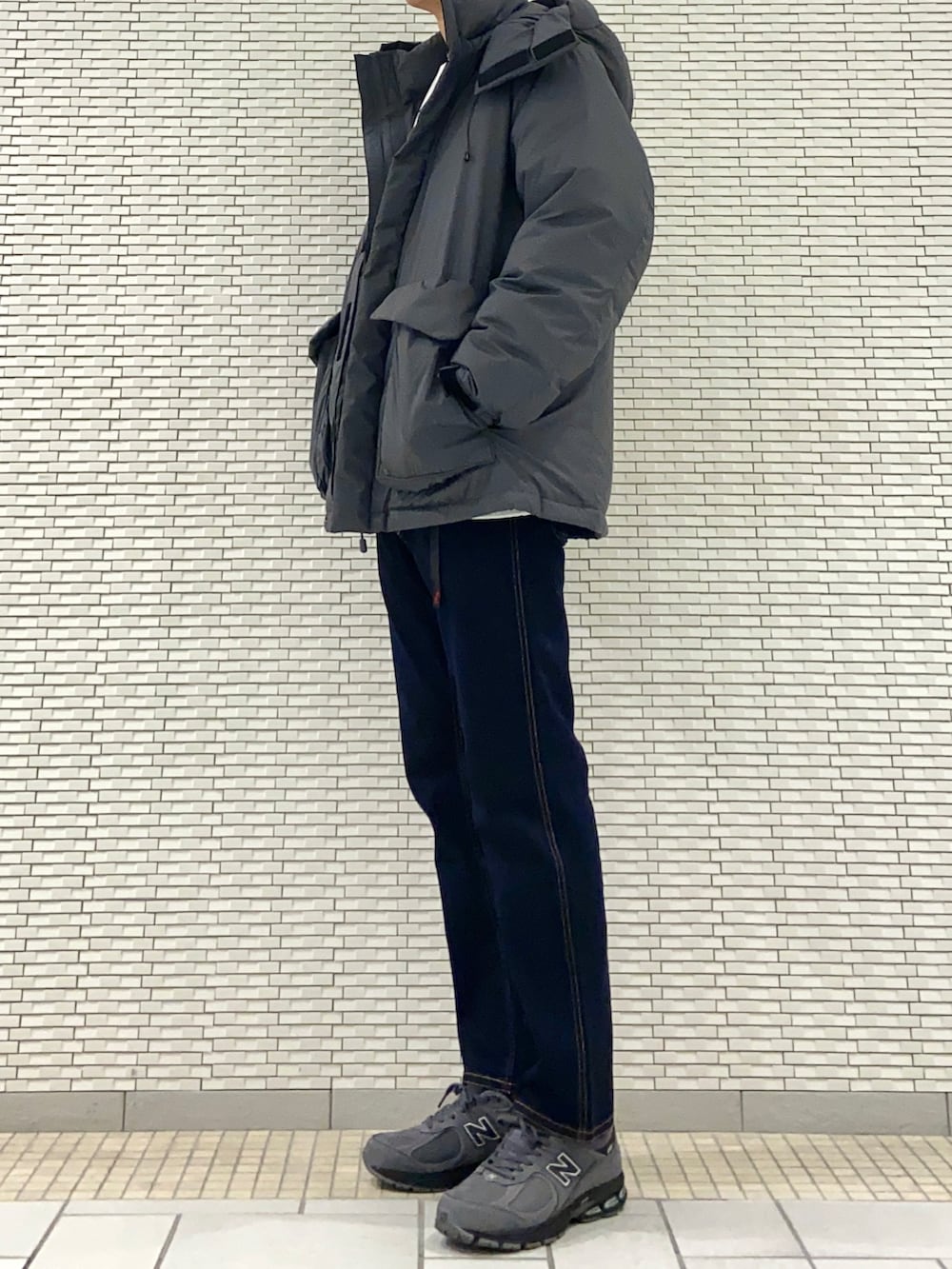 グレー系のダウンジャケット/コート、グレー系のスウェット、ブルー系のその他パンツを着用したメンズの冬コーディネートの2枚目の写真