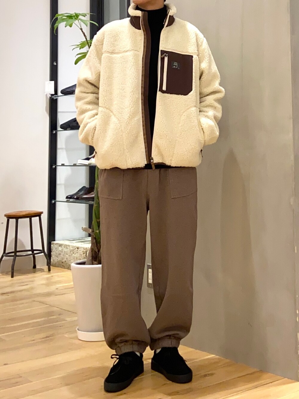 ホワイト系のブルゾン、ブラック系のニット/セーター、ブラック系のその他シューズを着用したメンズの冬コーディネートの3枚目の写真