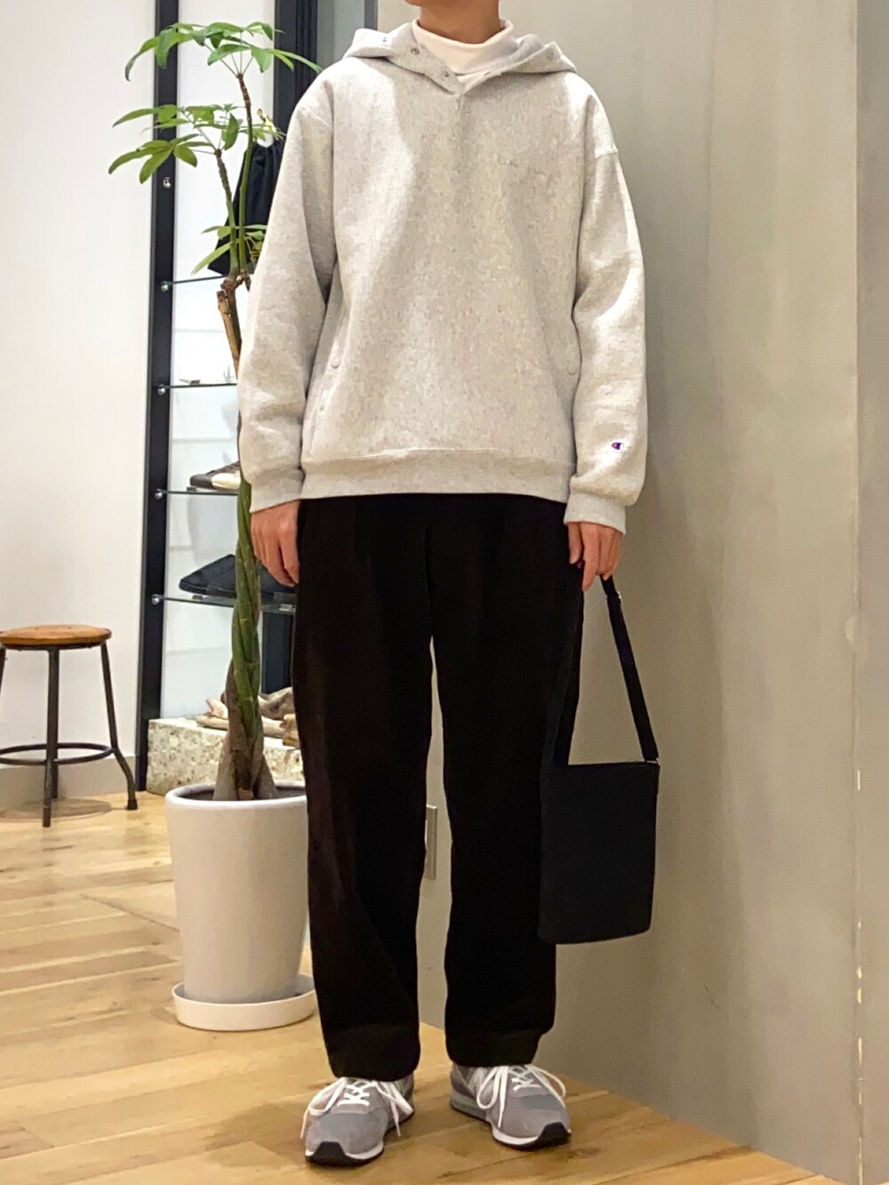 グレー系のパーカー、ホワイト系のTシャツ/カットソー、ブラック系のショルダーバッグを着用したメンズの秋コーディネートの3枚目の写真