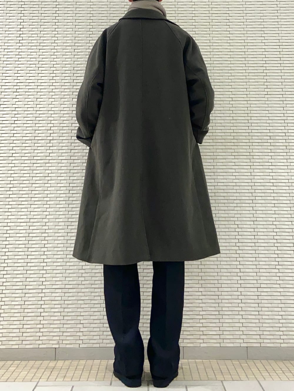 グリーン系のステンカラーコート、グレー系のTシャツ/カットソー、ブラック系のその他パンツを着用したメンズの冬コーディネートの3枚目の写真