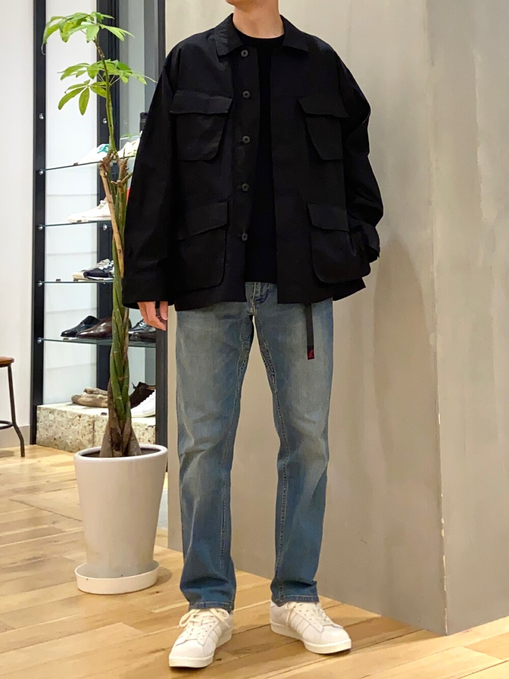 ブラック系のミリタリージャケット、ブラック系のニット/セーター、ブルー系のその他パンツを着用したメンズの春コーディネートの3枚目の写真