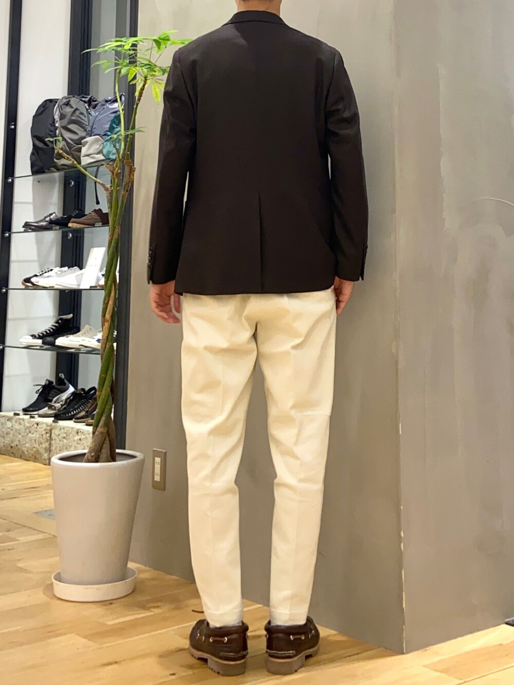ブラウン系のその他アウター、ホワイト系のニット/セーター、ホワイト系のチノパンツを着用したメンズの秋コーディネートの4枚目の写真