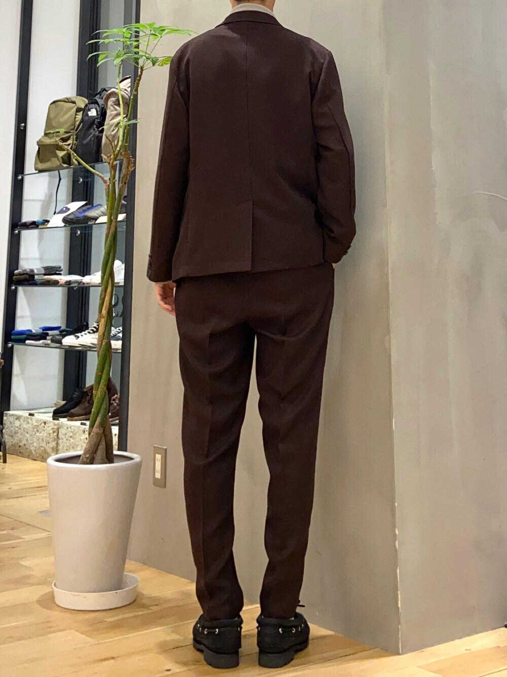 ブラウン系のその他アウター、ベージュ系のニット/セーター、ブラウン系のスーツパンツを着用したメンズの冬コーディネートの4枚目の写真