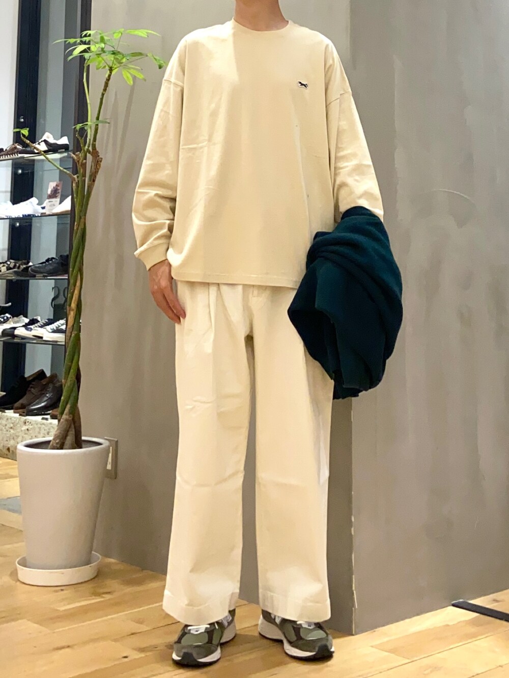 グリーン系のカーディガン/ボレロ、ベージュ系のTシャツ/カットソー、ホワイト系のチノパンツを着用したメンズの夏コーディネートの2枚目の写真