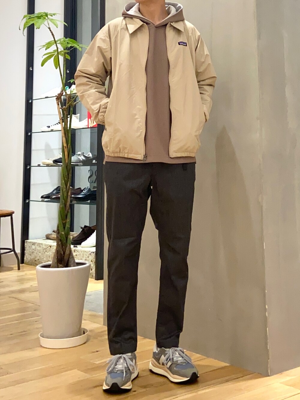 ブラウン系のパーカー、グレー系のその他パンツ、グレー系のスニーカーを着用したメンズの春コーディネートの3枚目の写真