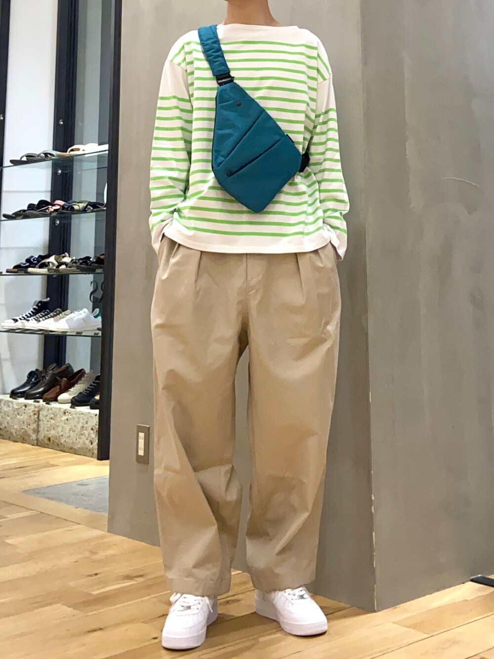 グリーン系のTシャツ/カットソー、グリーン系のショルダーバッグ、ベージュ系のその他パンツを着用したメンズの春コーディネートの2枚目の写真