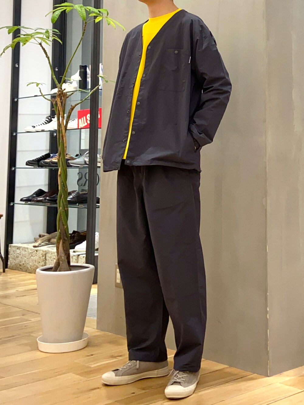 グレー系のナイロンジャケット、グレー系のその他パンツ、イエロー系のTシャツ/カットソーを着用したメンズの春コーディネートの3枚目の写真