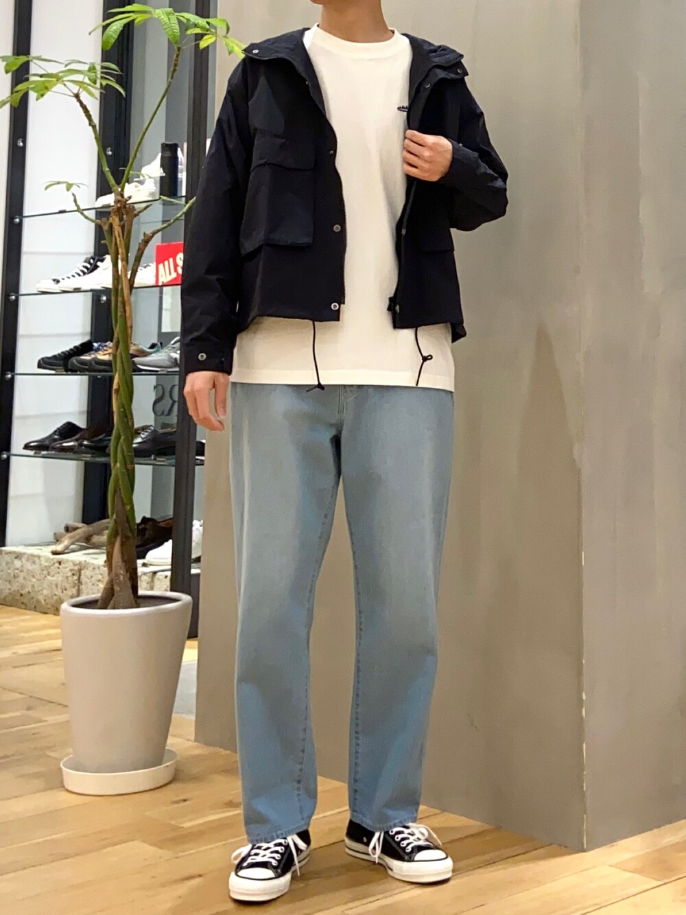 ブラック系のマウンテンパーカー、ホワイト系のTシャツ/カットソー、ブルー系のデニムパンツを着用したメンズの春コーディネートの4枚目の写真
