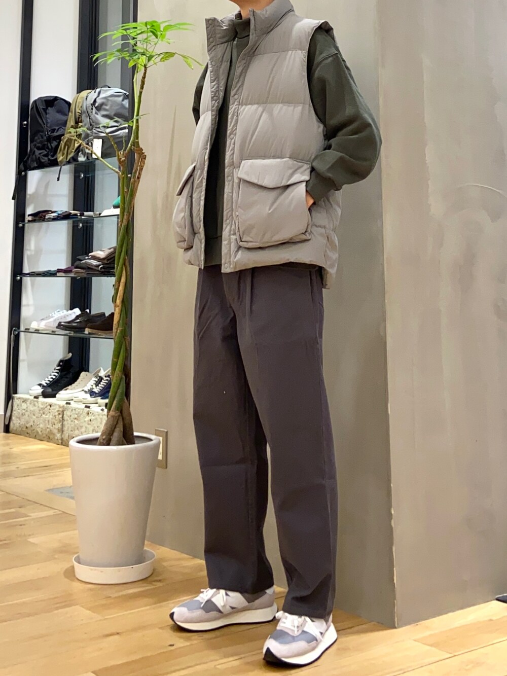 グレー系のダウンベスト、グリーン系のスウェット、グレー系のその他パンツを着用したメンズの秋コーディネートの3枚目の写真