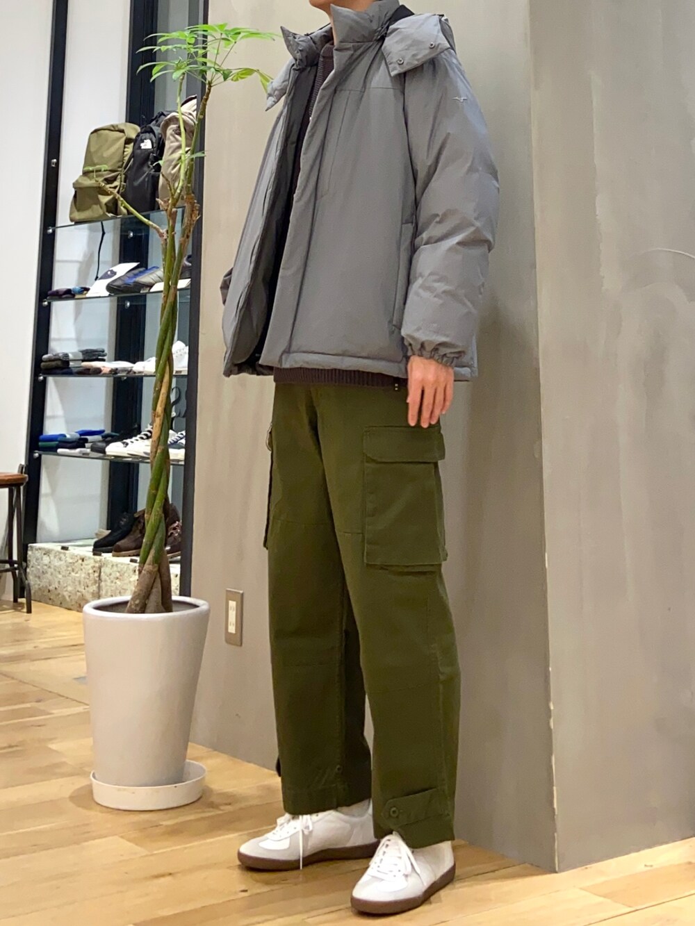 グレー系のダウンジャケット/コート、グレー系のニット/セーター、ホワイト系のスニーカーを着用したメンズの冬コーディネートの4枚目の写真