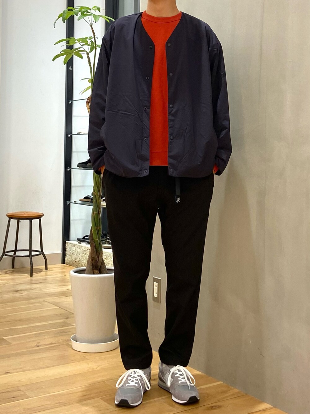 オレンジ系のTシャツ/カットソー、ブラック系のカーディガン/ボレロ、ブラック系のその他パンツを着用したメンズの秋コーディネートの2枚目の写真