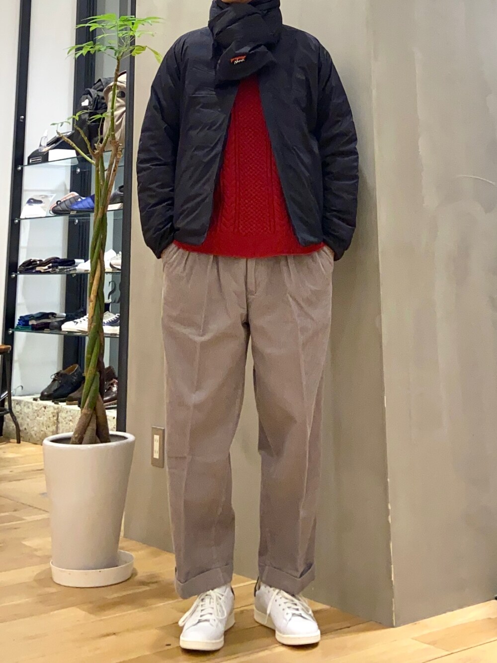 レッド系のニット/セーター、グレー系のその他パンツ、グリーン系のスニーカーを着用したメンズの冬コーディネートの2枚目の写真