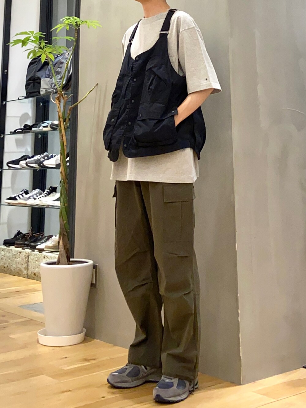 ブラック系のベスト、グリーン系のカーゴパンツを着用したメンズの春コーディネートの2枚目の写真