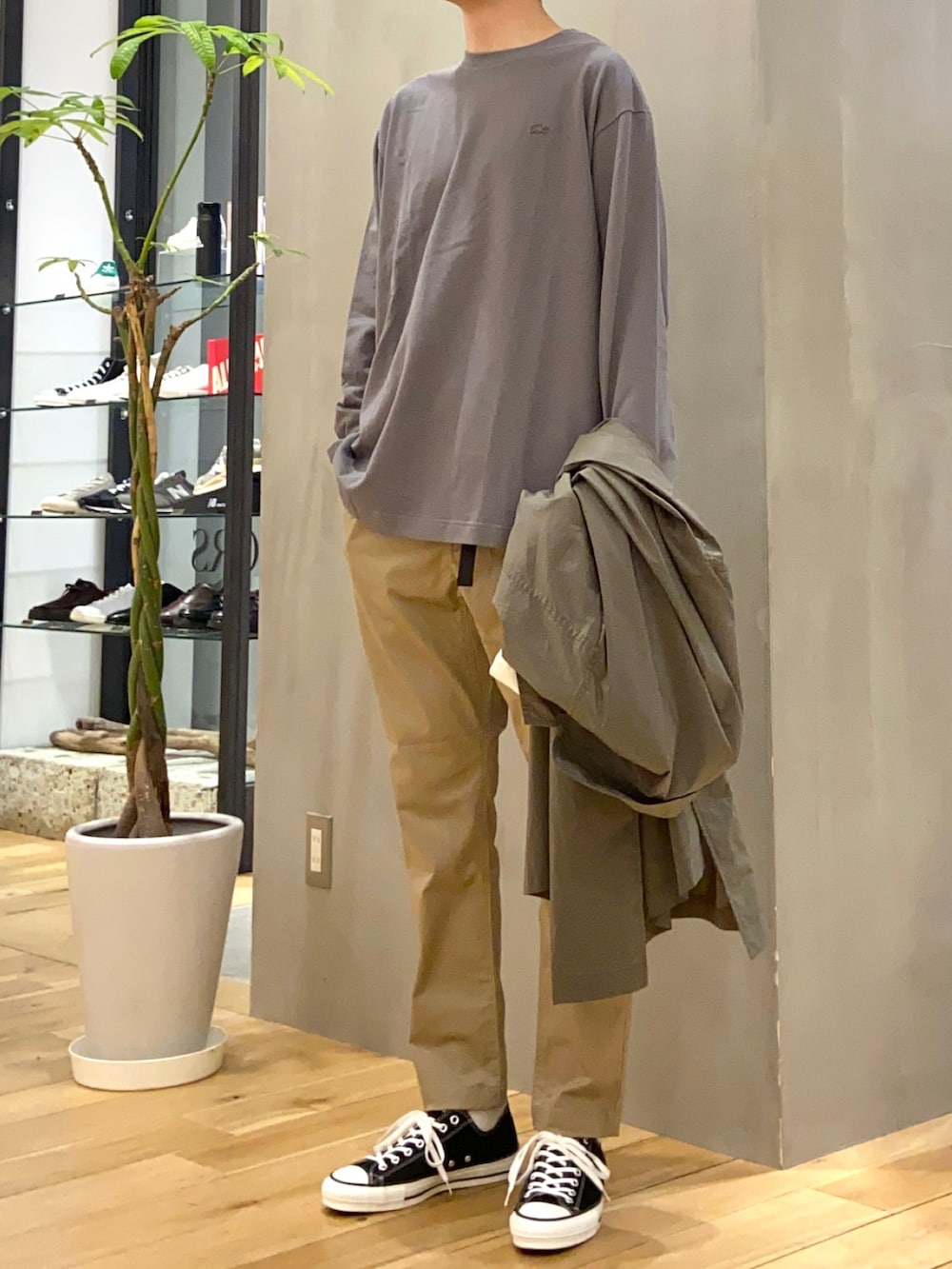 グレー系のTシャツ/カットソー、グリーン系のステンカラーコート、ベージュ系のその他パンツを着用したメンズの春コーディネートの3枚目の写真