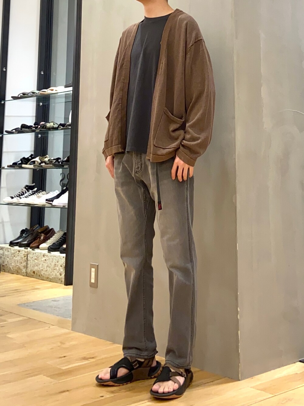 ブラウン系のカーディガン/ボレロ、グレー系のTシャツ/カットソー、ブラック系のその他パンツを着用したメンズの春コーディネートの2枚目の写真