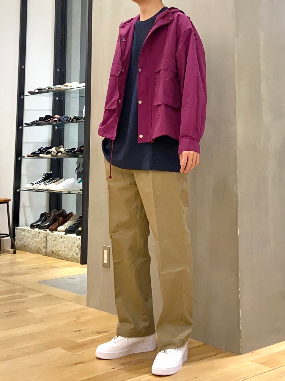 ブルー系のTシャツ/カットソー、パープル系のマウンテンパーカー、ベージュ系のチノパンツを着用したメンズの春コーディネートの3枚目の写真