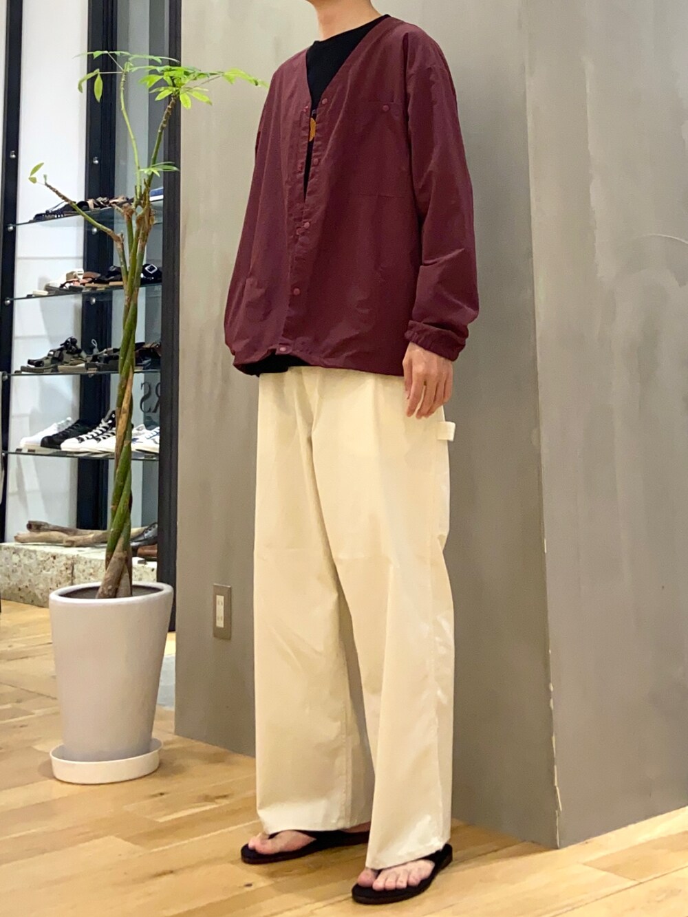 レッド系のブルゾン、ブラック系のTシャツ/カットソー、ホワイト系のその他パンツを着用したメンズの秋コーディネートの3枚目の写真