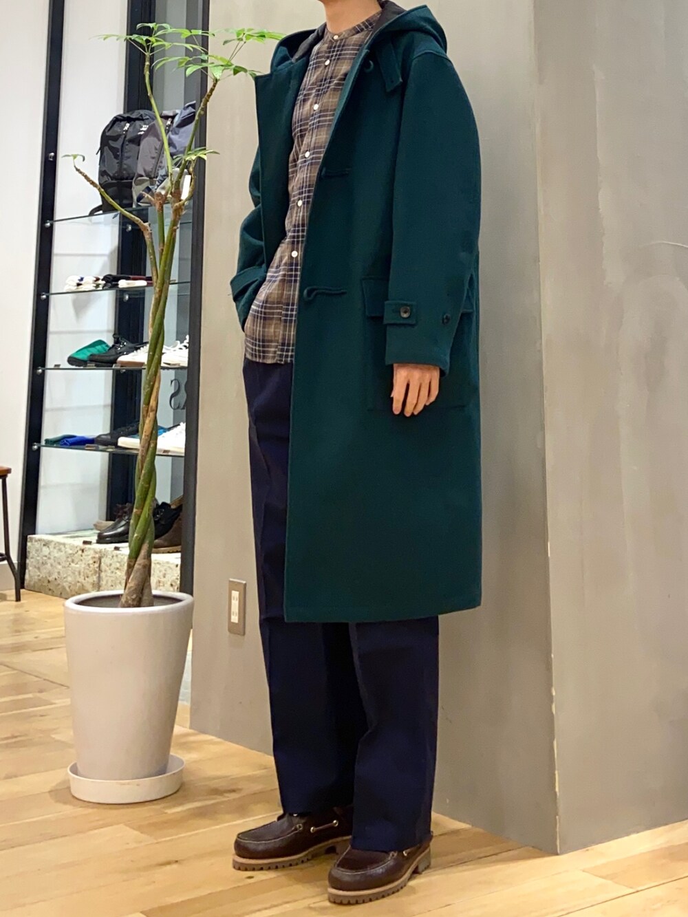 グリーン系のダッフルコート、ブラウン系のシャツ/ブラウス、ブルー系のその他パンツを着用したメンズの冬コーディネートの3枚目の写真