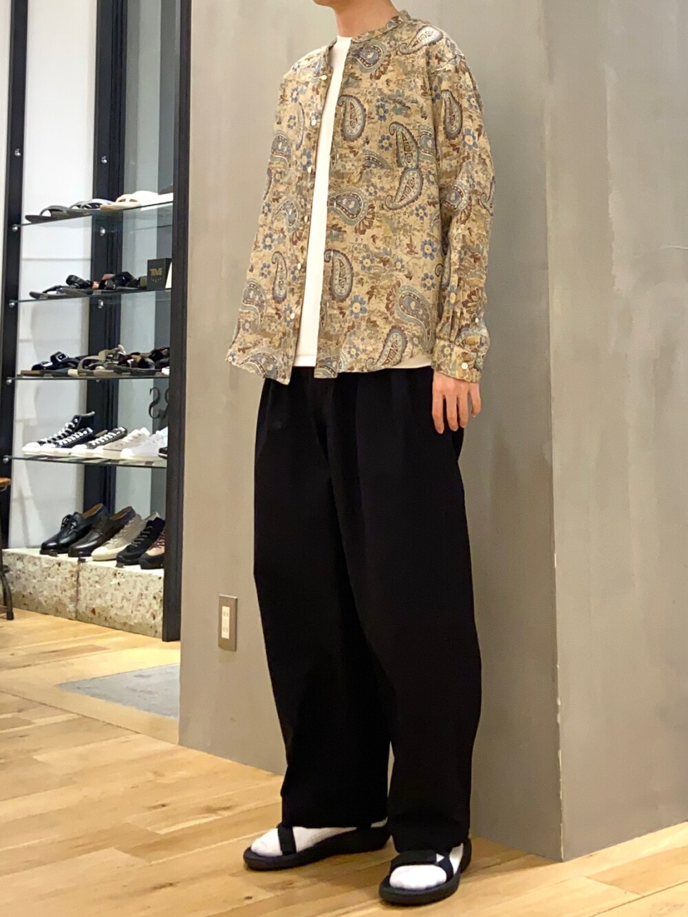 ブラウン系のシャツ/ブラウス、ホワイト系のTシャツ/カットソー、ブラック系のサンダルを着用したメンズの春コーディネートの3枚目の写真