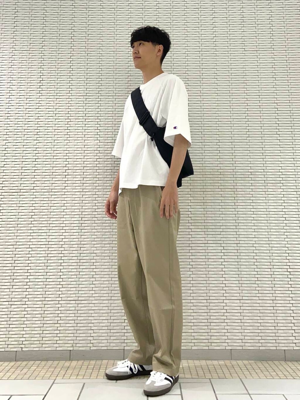 ホワイト系のTシャツ/カットソー、ブラック系のショルダーバッグ、ホワイト系のスニーカーを着用したメンズの夏コーディネートの2枚目の写真