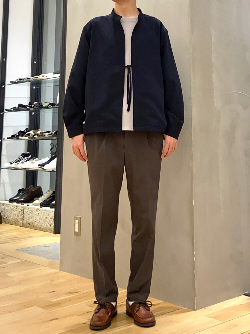 グレー系のTシャツ/カットソー、ブルー系のブルゾン、グリーン系のスーツパンツを着用したメンズの春コーディネートの4枚目の写真