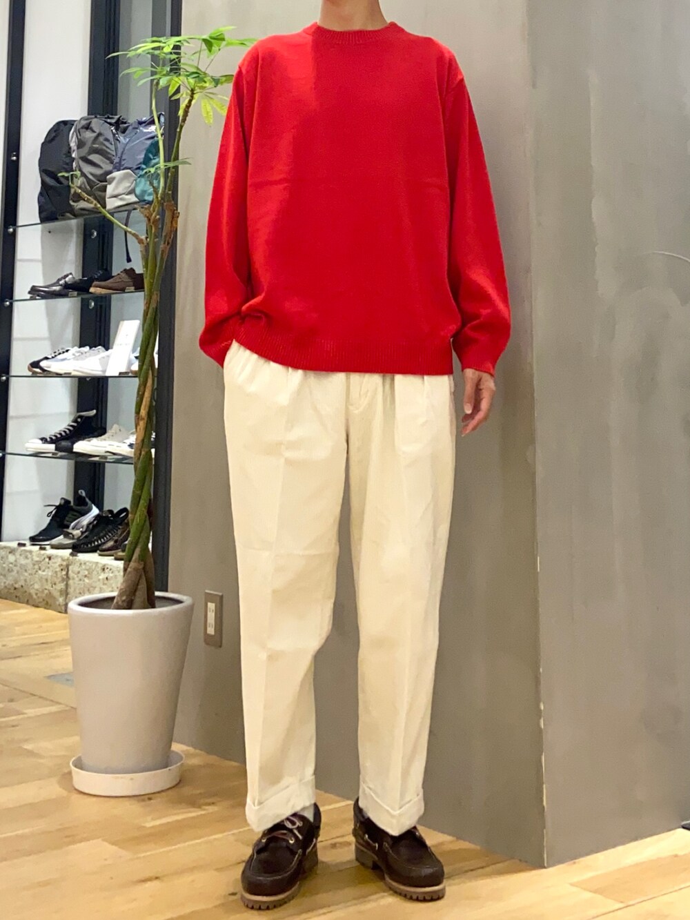 ブラック系のダウンジャケット/コート、レッド系のニット/セーター、ホワイト系のその他パンツを着用したメンズの秋コーディネートの2枚目の写真