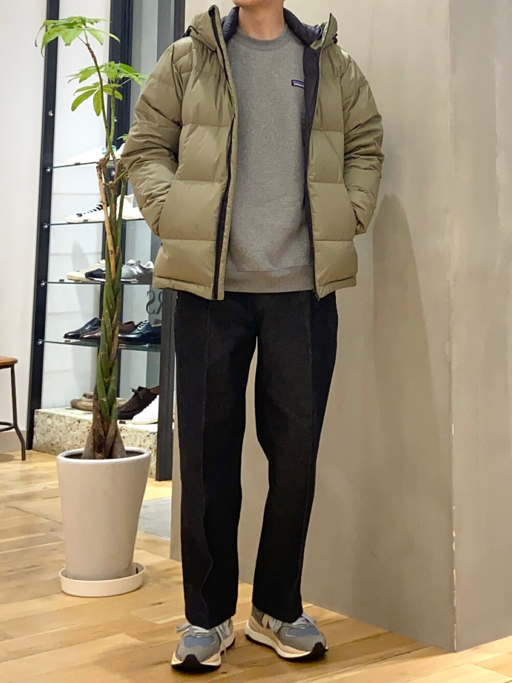 グリーン系のダウンジャケット/コート、ブルー系のデニムパンツ、グレー系のスニーカーを着用したメンズの冬コーディネートの3枚目の写真