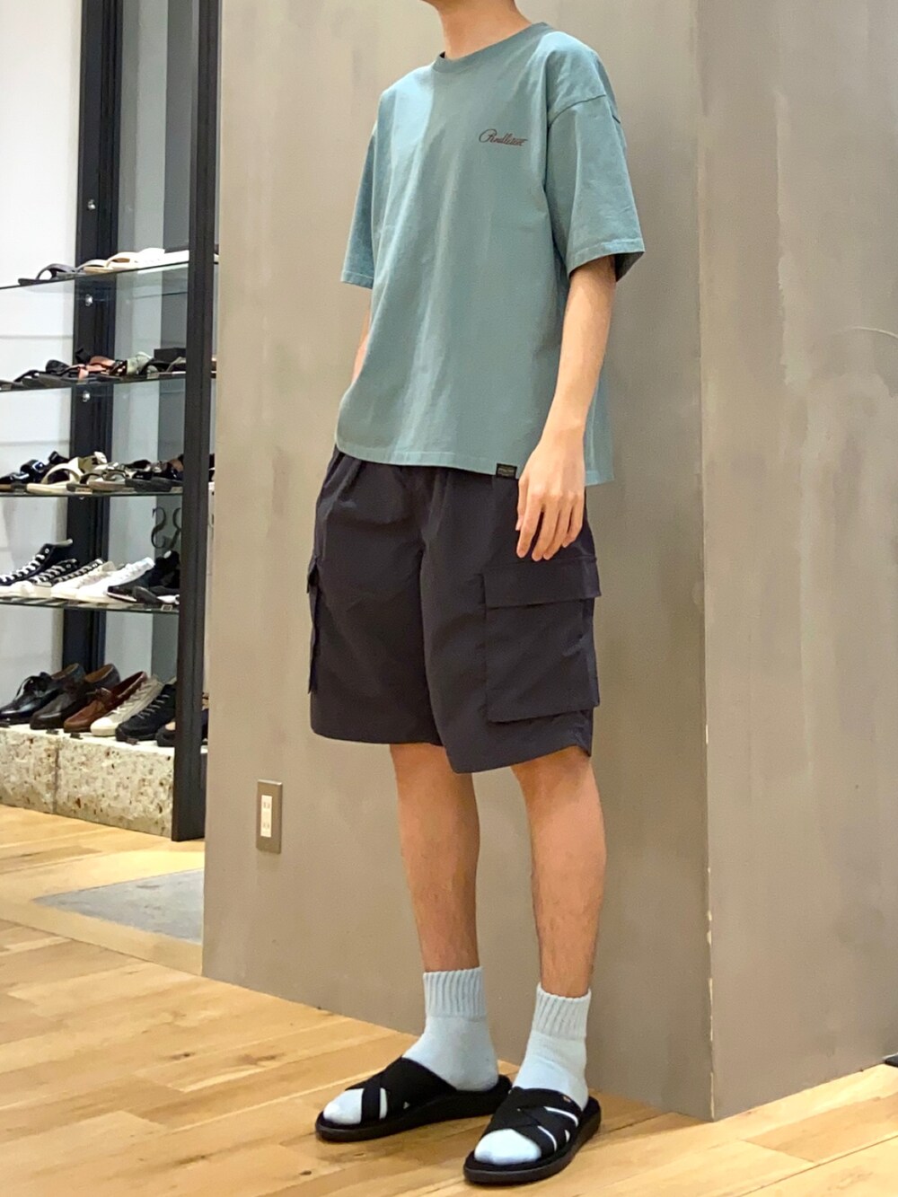 グリーン系のTシャツ/カットソー、グレー系のその他パンツ、ブラック系のサンダルを着用したメンズの春コーディネートの3枚目の写真
